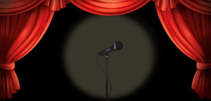 Grammys Graphic pictures a spotlight on a microphone. Surrounding the microphone are red curtains.