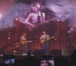 Gracie Abrams on stage with her guitar