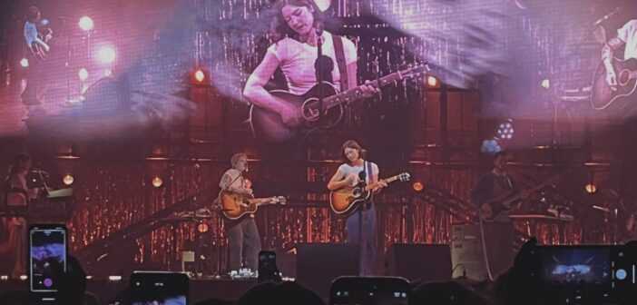 Gracie Abrams on stage with her guitar